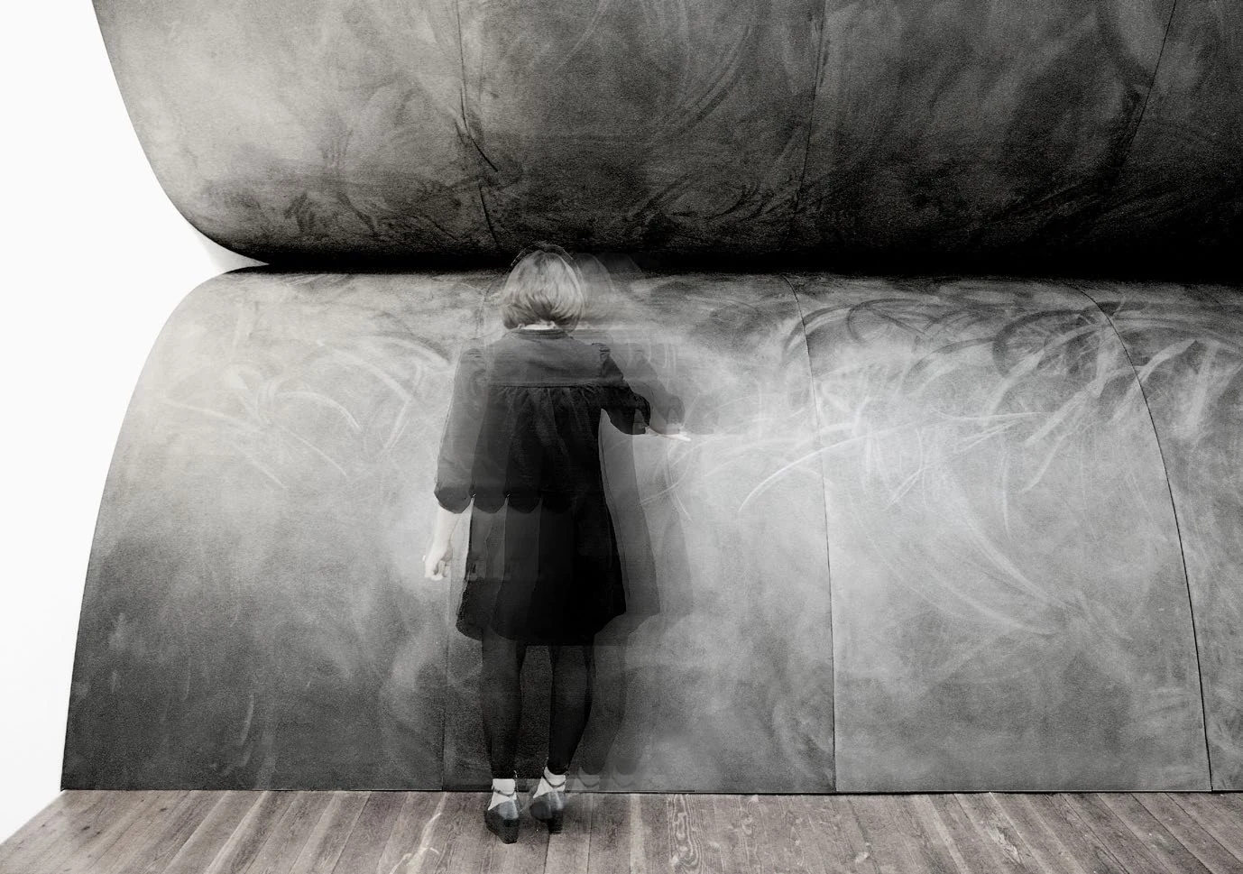 A viewer standing close to the monumental curved installation Un Orizzonte