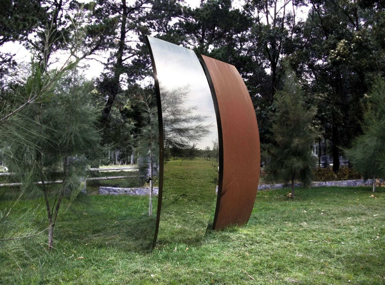 A mirrored and weathering steel sculpture in the MACA sculpture park