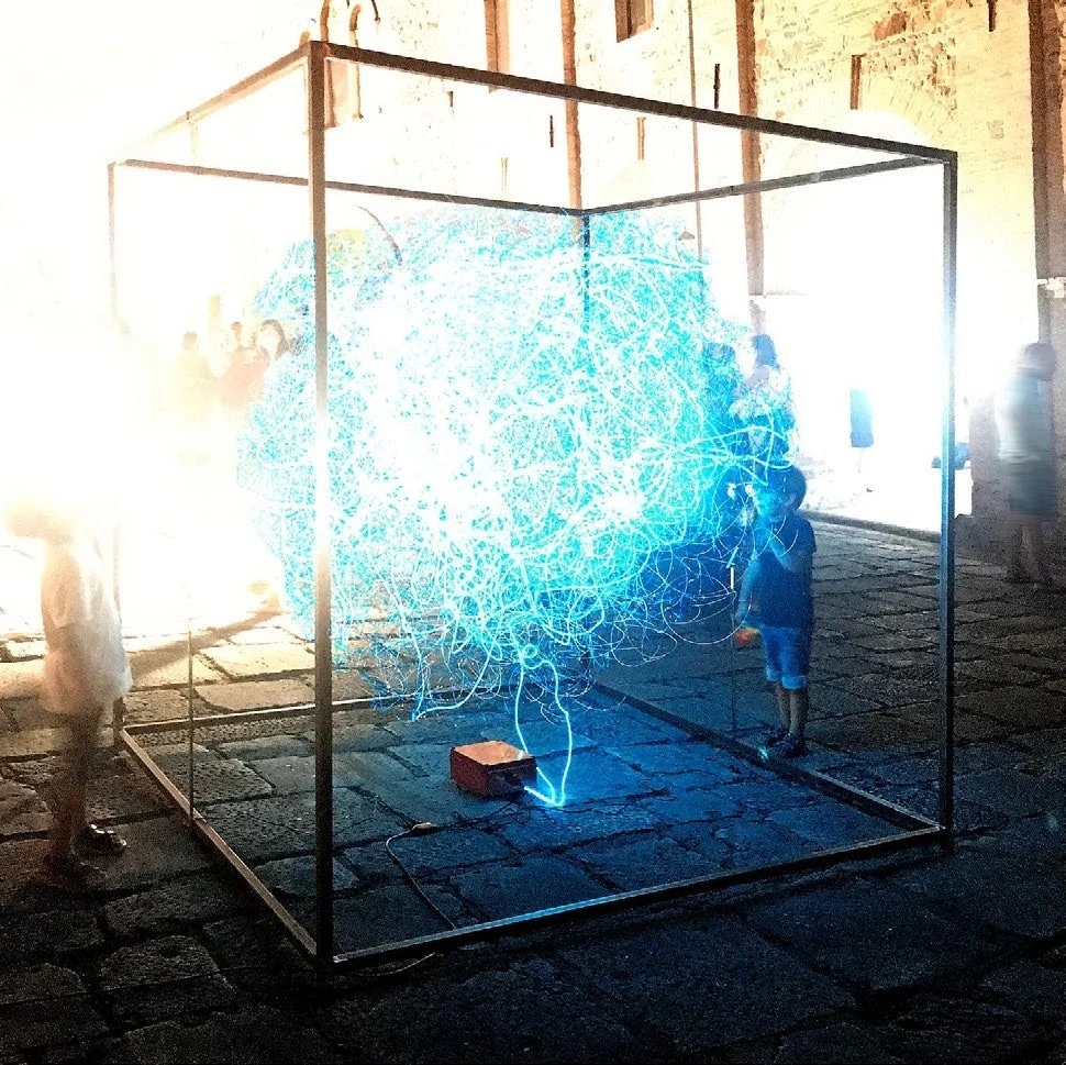 The Human Connection, blue light lines suspended inside a steel cube