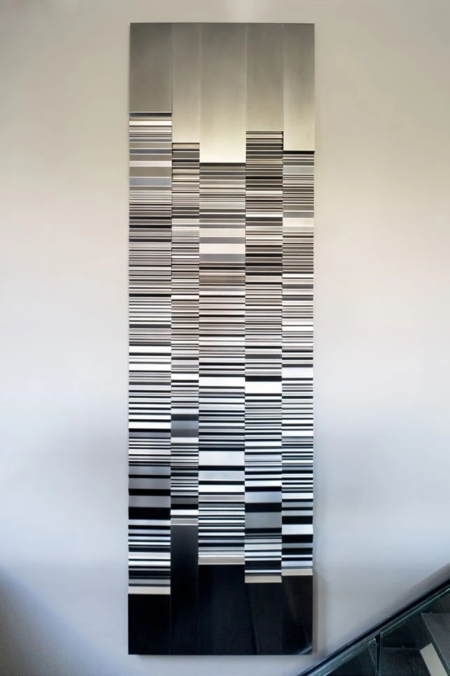 A tall polished stainless steel work installed against a wall